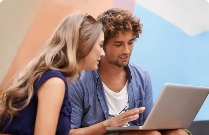 Cuplu uitându-se la laptop