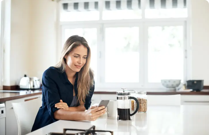 Femeie folosind telefonul la masă