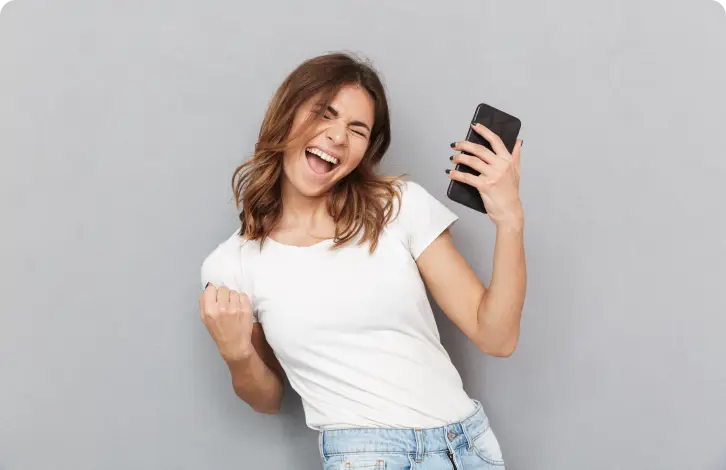 Femeie veselă ținând telefonul